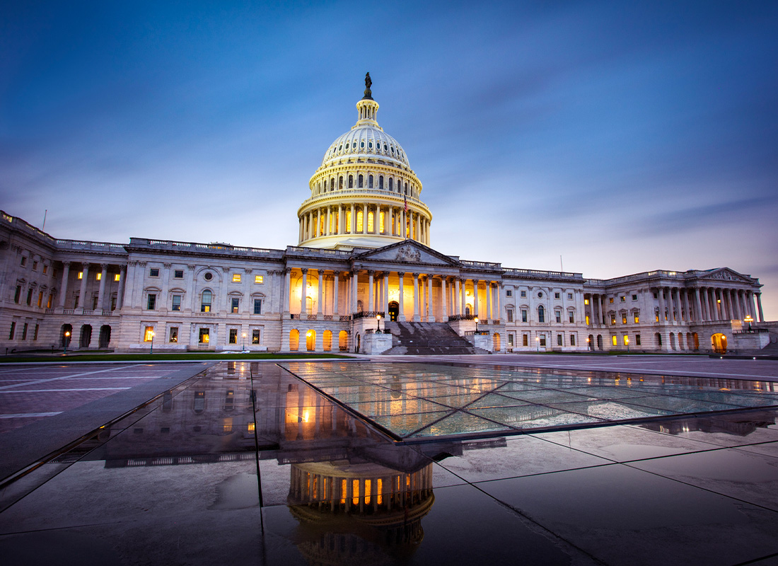 Capitol building in Washington DC illuminated against a stormy sky