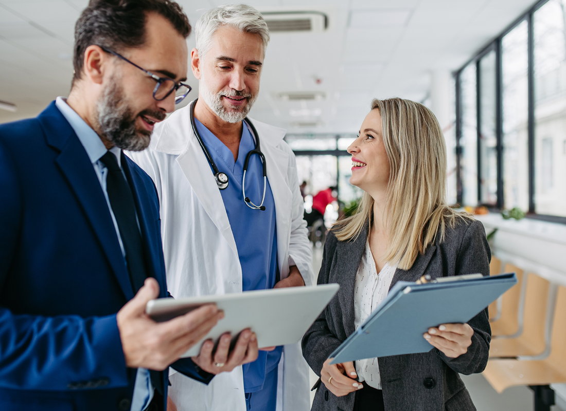 Two laboratory sales reps—one male and one female—meet with a male doctor.